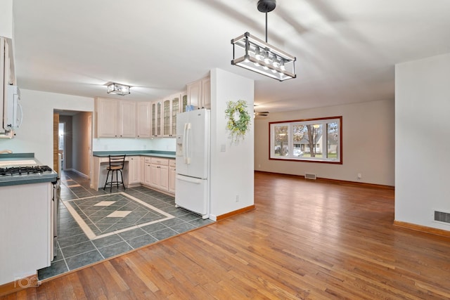 kitchen with dark hardwood / wood-style flooring, white appliances, decorative light fixtures, and ceiling fan