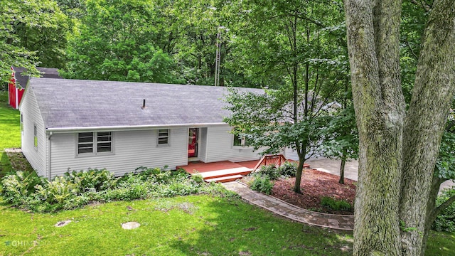 ranch-style home with a deck and a front lawn