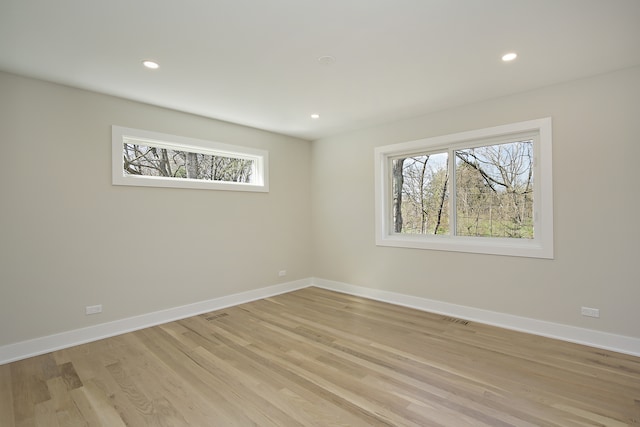 spare room with a healthy amount of sunlight and light hardwood / wood-style flooring