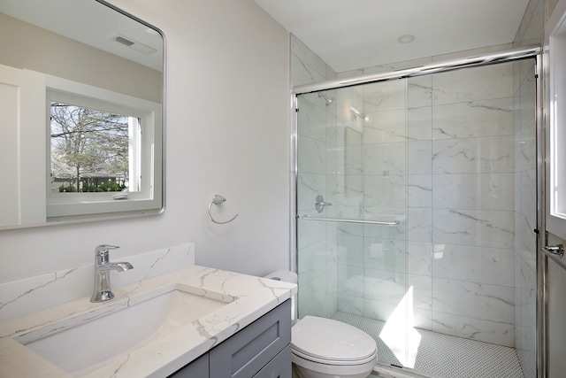 bathroom featuring vanity, toilet, and an enclosed shower