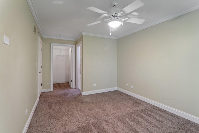 empty room with crown molding, ceiling fan, and carpet flooring