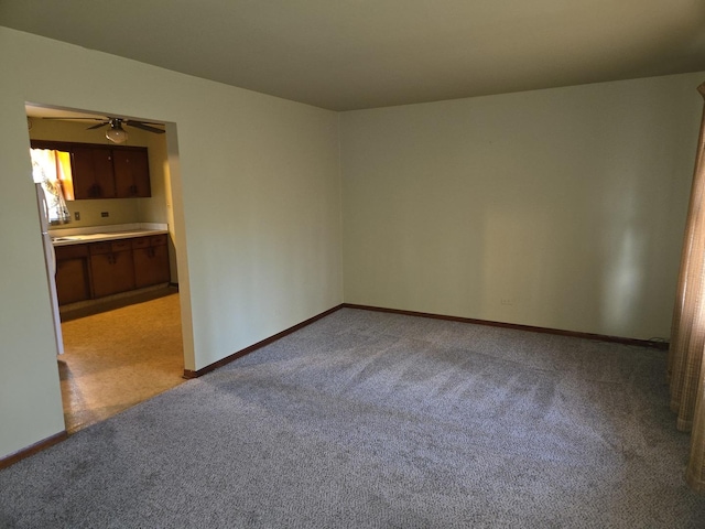 carpeted empty room featuring ceiling fan