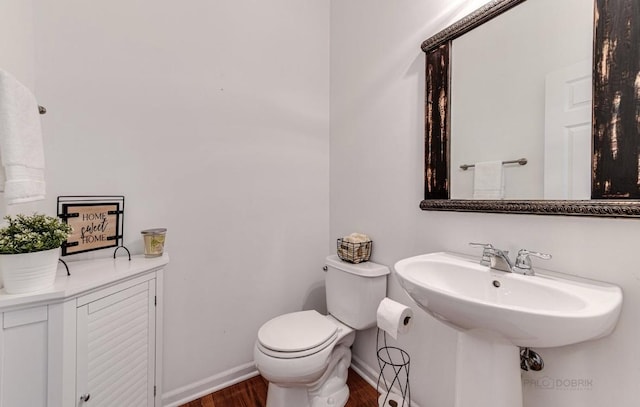 bathroom with toilet and hardwood / wood-style flooring