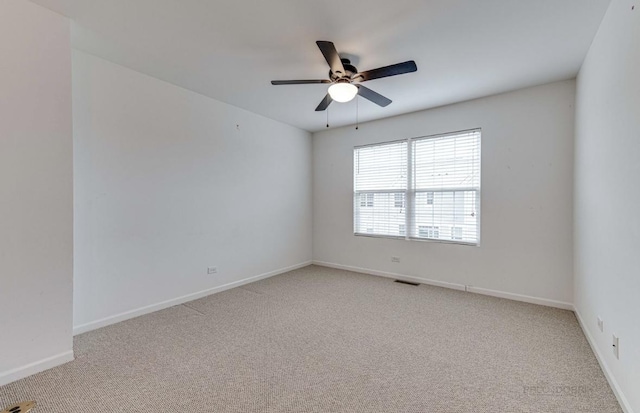 carpeted spare room with ceiling fan