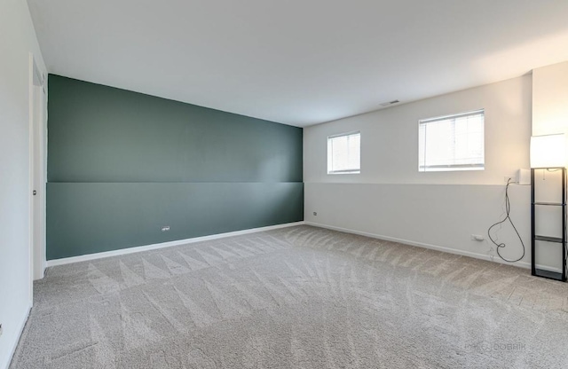 unfurnished room with light colored carpet and vaulted ceiling