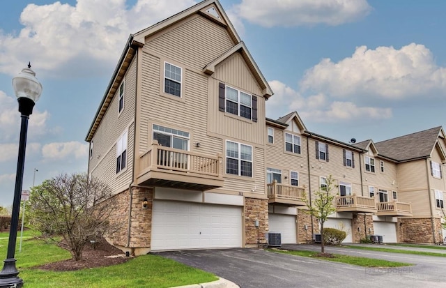 exterior space featuring central AC, a balcony, and a garage