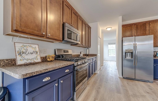 kitchen with light hardwood / wood-style floors and stainless steel appliances