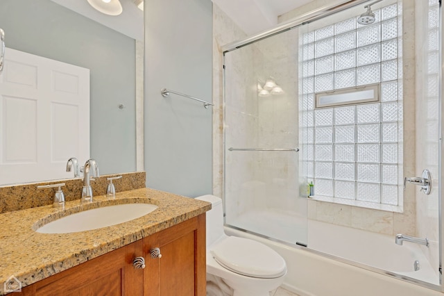 full bathroom featuring vanity, toilet, and bath / shower combo with glass door