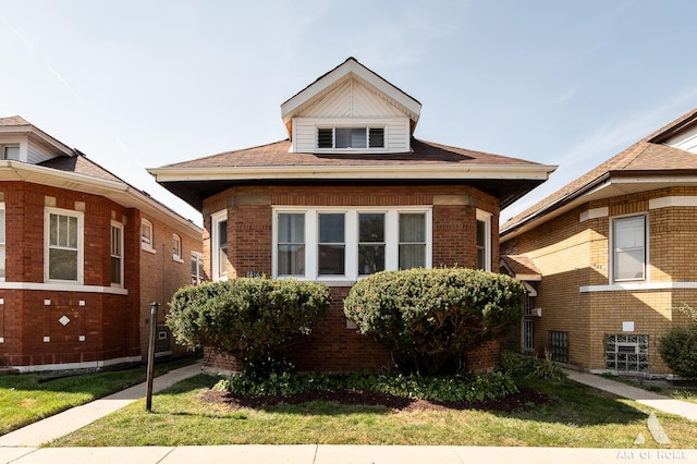 bungalow-style home with a front lawn