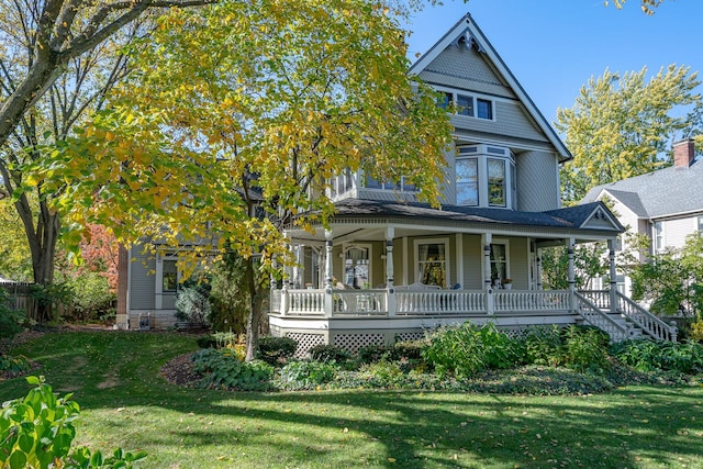 victorian-style house with a front lawn and a porch