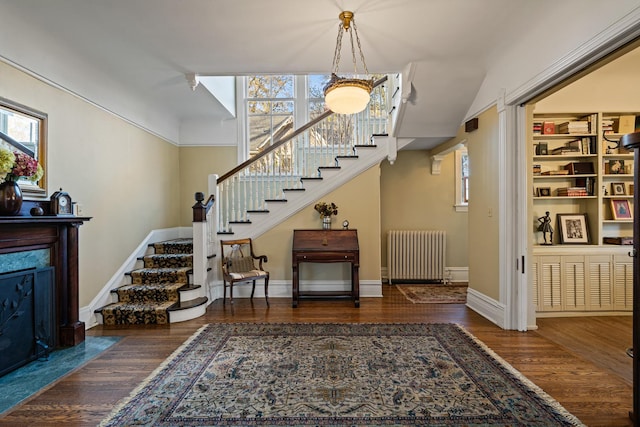 interior space with plenty of natural light, dark hardwood / wood-style floors, and radiator