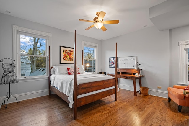 bedroom featuring hardwood / wood-style flooring, multiple windows, and ceiling fan