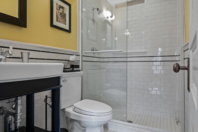 bathroom featuring tile walls, toilet, a shower with door, and vanity