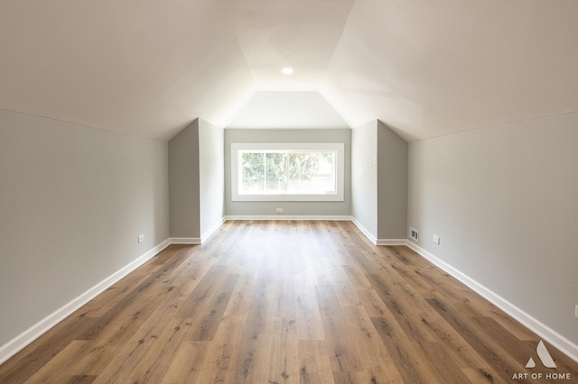 bonus room with lofted ceiling and wood-type flooring