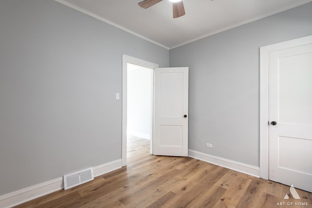 empty room with ceiling fan, ornamental molding, and light wood-type flooring