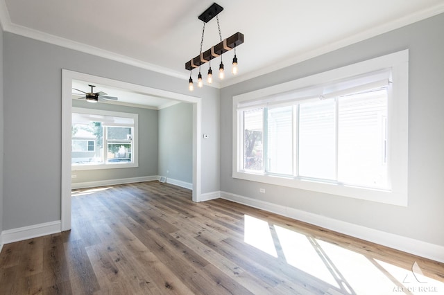 empty room with wood-type flooring, ornamental molding, and a wealth of natural light