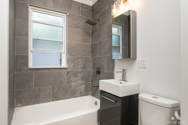 full bathroom with vanity, tiled shower / bath combo, and toilet