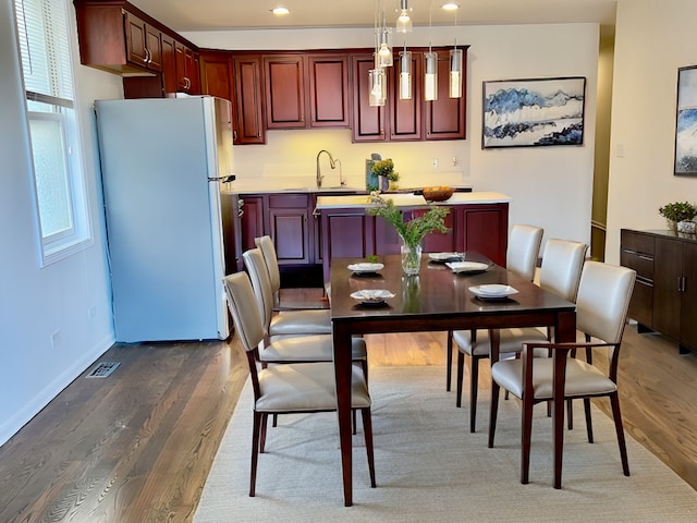 dining space featuring dark wood-type flooring and sink