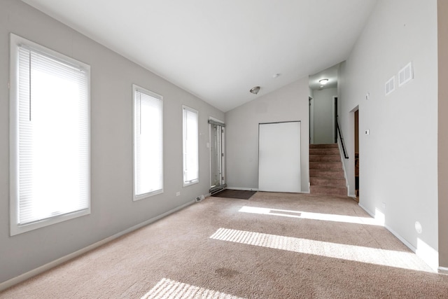 carpeted spare room featuring lofted ceiling