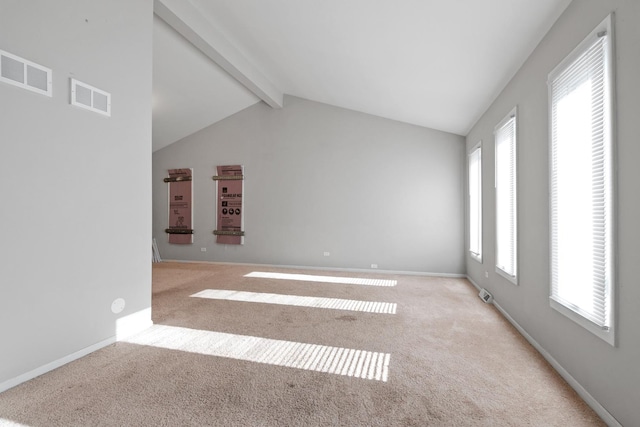 carpeted spare room featuring vaulted ceiling with beams