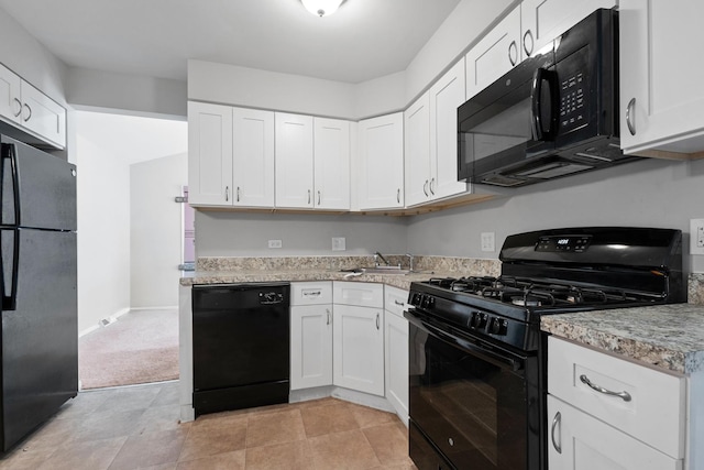 kitchen featuring black appliances, light colored carpet, white cabinetry, and sink