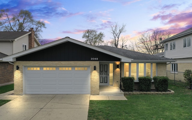 view of front of home featuring a garage and a yard