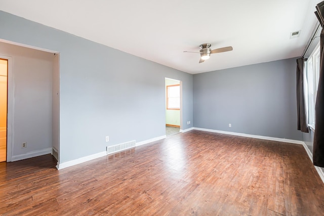 empty room with ceiling fan and dark hardwood / wood-style flooring