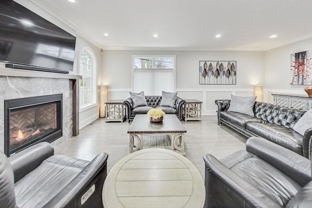 living room with a premium fireplace and crown molding