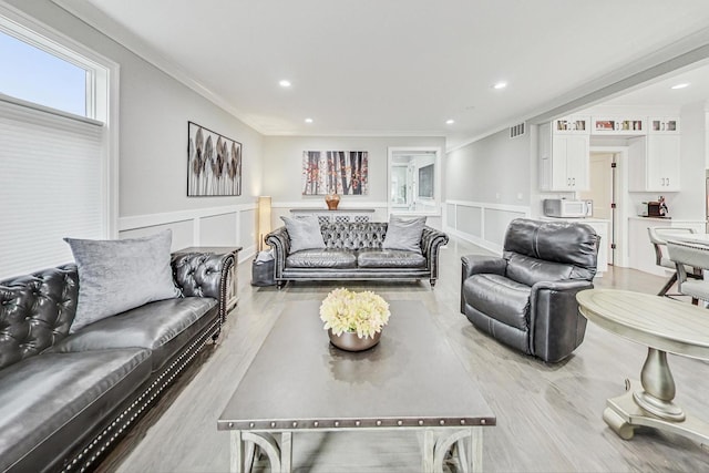 living room with light hardwood / wood-style flooring and crown molding