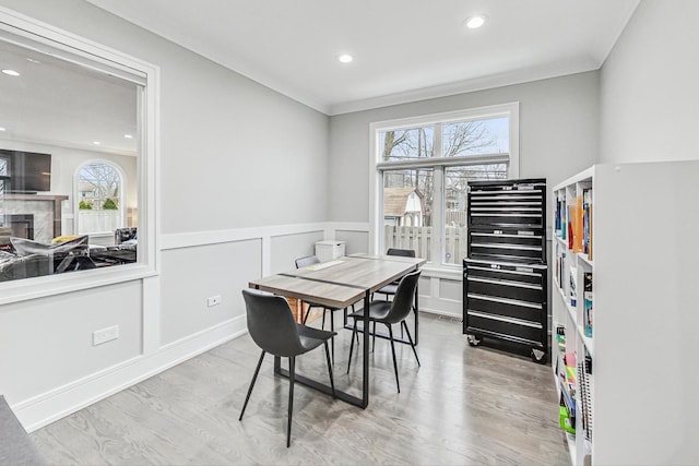 dining space featuring a wealth of natural light, light wood-type flooring, and ornamental molding