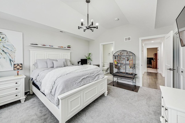 bedroom featuring a notable chandelier, ensuite bathroom, lofted ceiling, and dark wood-type flooring