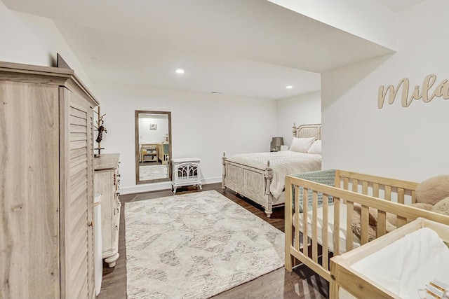 bedroom featuring dark hardwood / wood-style flooring and a nursery area