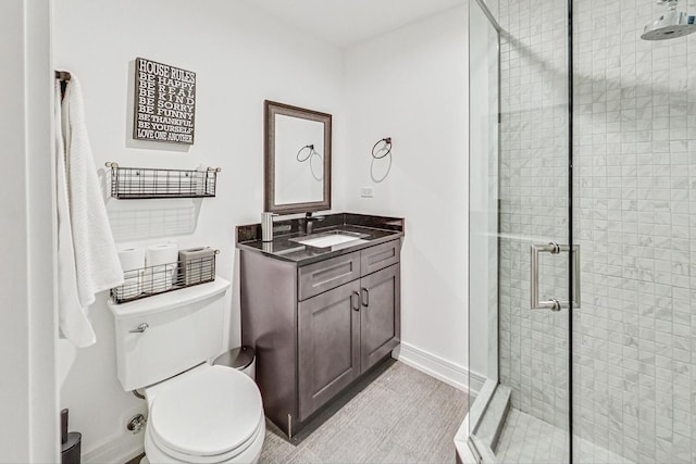 bathroom with vanity, toilet, and an enclosed shower