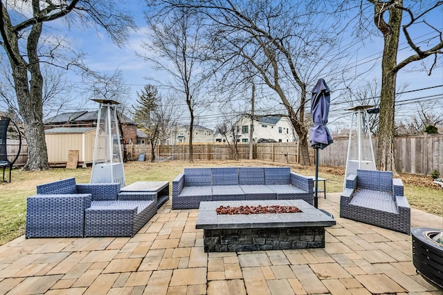 view of patio with a storage shed and an outdoor living space with a fire pit