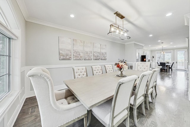 dining area featuring hardwood / wood-style flooring and ornamental molding