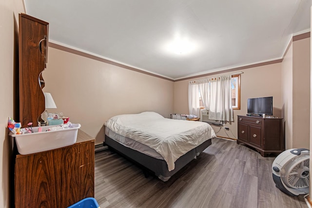 bedroom with hardwood / wood-style floors, baseboard heating, and ornamental molding