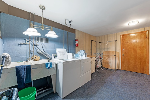 washroom with washing machine and dryer and wood walls