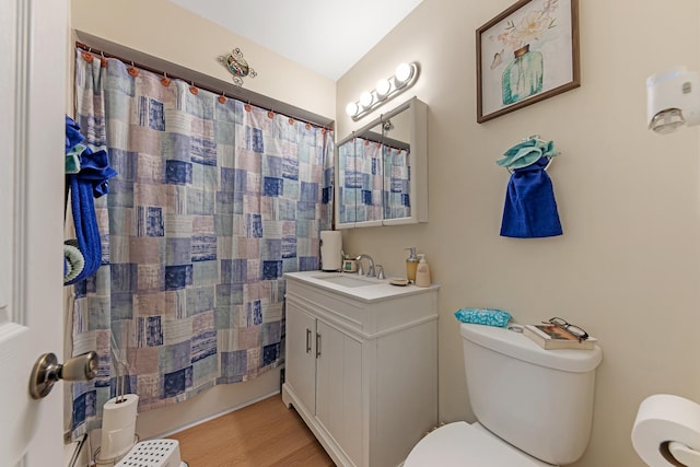 bathroom with a shower with shower curtain, vanity, vaulted ceiling, wood-type flooring, and toilet