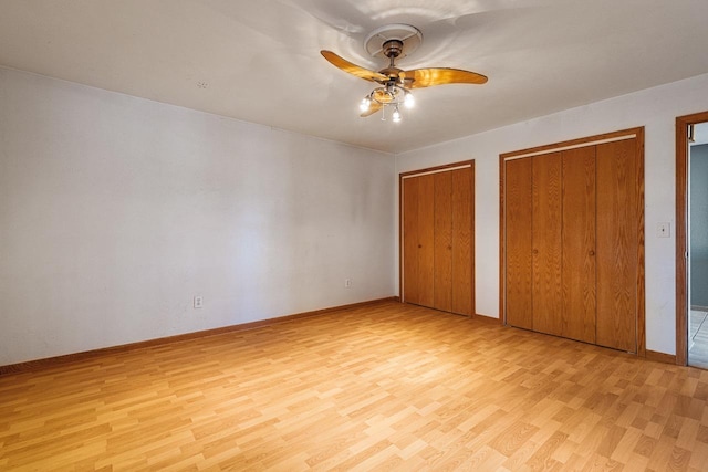 unfurnished bedroom featuring light wood-type flooring, two closets, and ceiling fan