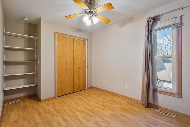 unfurnished bedroom featuring light hardwood / wood-style floors, a closet, and ceiling fan