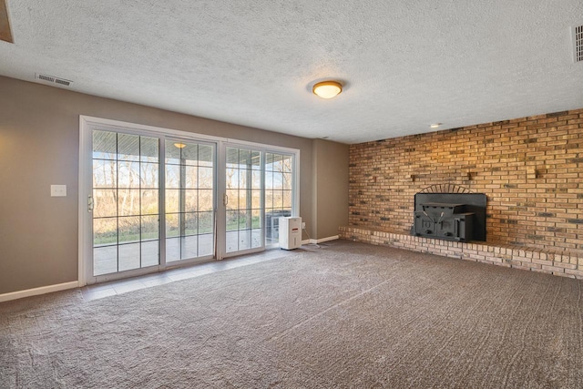 unfurnished living room with carpet, a textured ceiling, and a wood stove