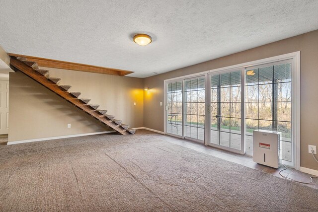 unfurnished room with a textured ceiling and light colored carpet