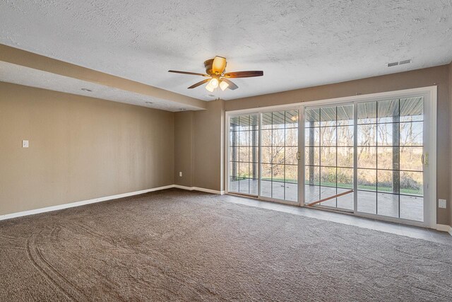 carpeted spare room with ceiling fan and a textured ceiling