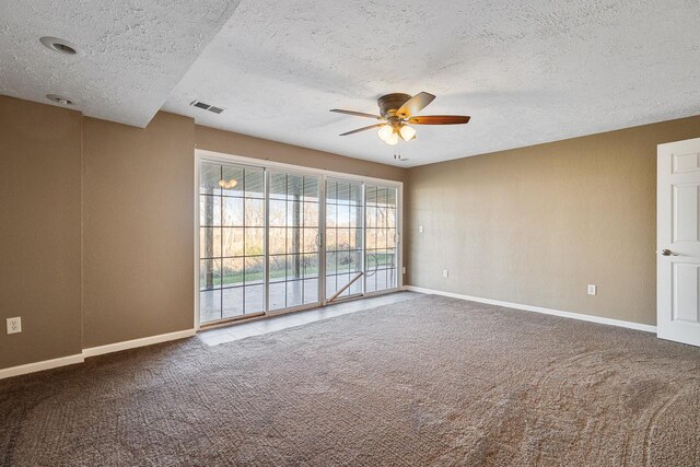 carpeted empty room with ceiling fan and a textured ceiling