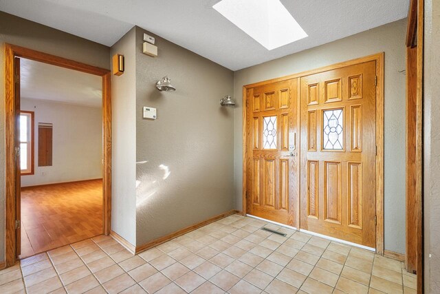 entrance foyer featuring a skylight, light hardwood / wood-style flooring, and a healthy amount of sunlight