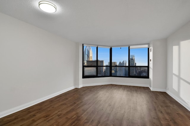 empty room featuring dark hardwood / wood-style flooring and a textured ceiling