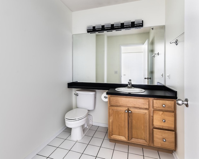 bathroom with toilet, vanity, and tile patterned floors