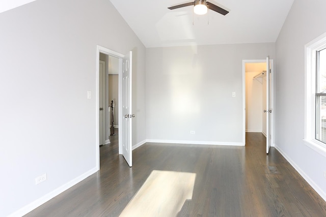 spare room featuring dark hardwood / wood-style floors, a healthy amount of sunlight, lofted ceiling, and ceiling fan