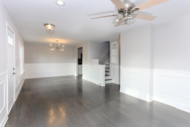 unfurnished room with ceiling fan with notable chandelier and dark wood-type flooring