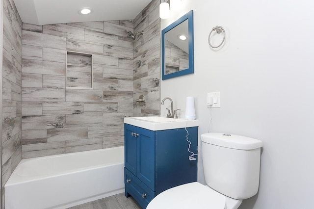 full bathroom with hardwood / wood-style floors, vanity, toilet, and tiled shower / bath